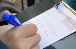 香港市民12月19日在大围港铁站外的街站写圣诞卡给12港人，表示会等他们返回香港，希望他们坚持下去。 (美国之音汤惠芸)