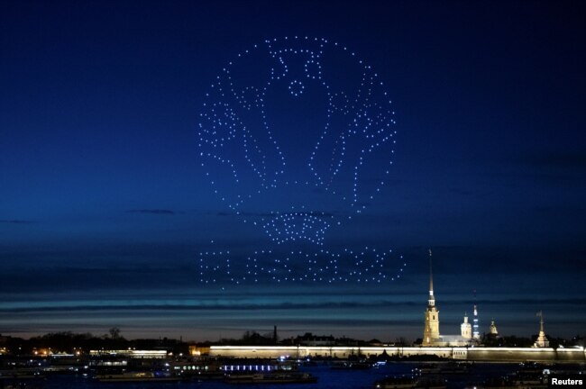 Drone yang membentuk logo Piala Eropa UEFA 2020 menerangi langit di atas Katedral Santo Petrus dan Paulus di Saint Petersburg, Rusia 2 Mei 2021. (Foto: Reuters)