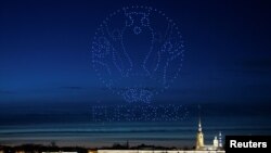 Des drones formant un logo de l'UEFA Euro Cup 2020 éclairent le ciel au-dessus de la cathédrale des Saints Pierre et Paul à Saint-Pétersbourg, en Russie, le 2 mai 2021. 