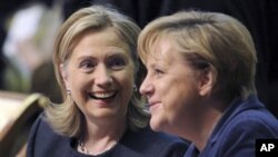 US Secretary of State Hillary Clinton, left, talks with German Chancellor Angela Merkel at the start of the OSCE Summit at the Palace of Independence in Astana, Kazakhstan, 01 Dec 2010