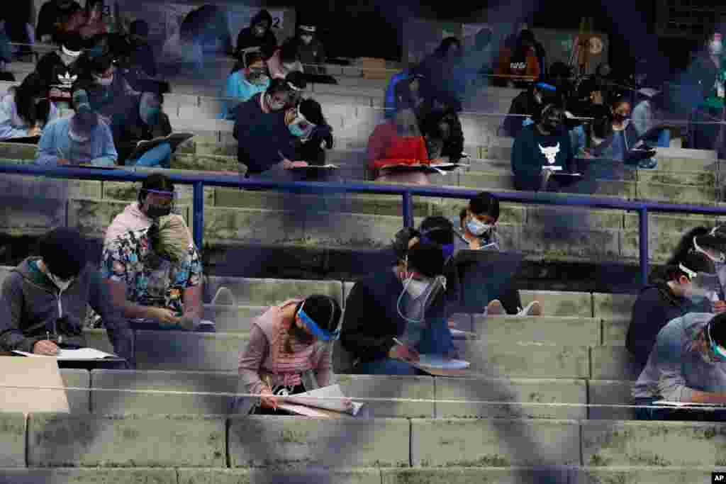 Students take an entrance exam for Mexico&#39;s National Autonomous University, amid the ongoing coronavirus pandemic, at the University Olympic Stadium in Mexico City.