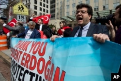 Supporters of Turkish President Recep Tayyip Erdogan hold banners during a rally outside the Brookings Institution in Washington, where Erdogan spoke, March 31, 2016.