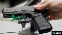 A man holds a Glock handgun during the annual National Rifle Association convention in Dallas, Texas, May 6, 2018. 