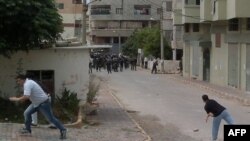 В сирійському місті Баньяс люди кидають каміння в поліцейських.