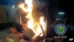 FILE - This file frame grab from video, provided by the Federal Aviation Administration (FAA) shows a test at the FAAs technical center in Atlantic City, N.J. last April, where a cargo container was packed with 5,000 rechargeable lithium-ion batteries. Officials say Jan. 27, 2016, a U.N. aviation panel is recommending a ban on shipping rechargeable batteries as cargo on passenger airliners because the batteries can create fires capable of destroying planes. 