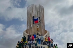 FILE - Supporters of Niger's ruling junta hold a Russian flag at the start of a protest called to fight for the country's freedom and push back against foreign interference in Niamey, Niger, on Aug. 3, 2023.