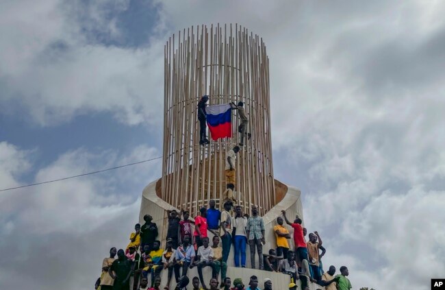 FILE - Supporters of Niger's ruling junta hold a Russian flag at the start of a protest called to fight for the country's freedom and push back against foreign interference in Niamey, Niger, on Aug. 3, 2023.