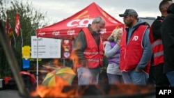 Employees hold a picket line as part of a strike against the sale of a controlling stake in Sanofi subsidiary Opella, outside the Sanofi manufacturing plant in Lisieux, northwestern France, Oct. 17, 2024.