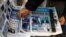 ARCHIVO - Una persona toma un periódico que anuncia la victoria del candidato presidencial Javier Milei en las primarias argentinas un día después de las elecciones, en Buenos Aires, Argentina, el 14 de agosto de 2023.