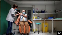 Dr. Christian Chidiac gets a Pfizer-BioNTech COVID-19 vaccine in La Croix-Rousse hospital, in Lyon, central France, Jan. 6, 2021. 