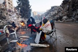 Sobrevivientes del terremoto se calientan junto a una hoguera entre escombros y temperaturas de congelación en Kahramanmaras, Turquía, el 13 de febrero de 2023.