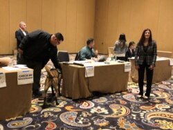 Democratic Party officials gather before the first voters arrive to caucus at this location in the Bellagio Hotel in Las Vegas, Feb. 22, 2020. (Carolyn Presutti/VOA)