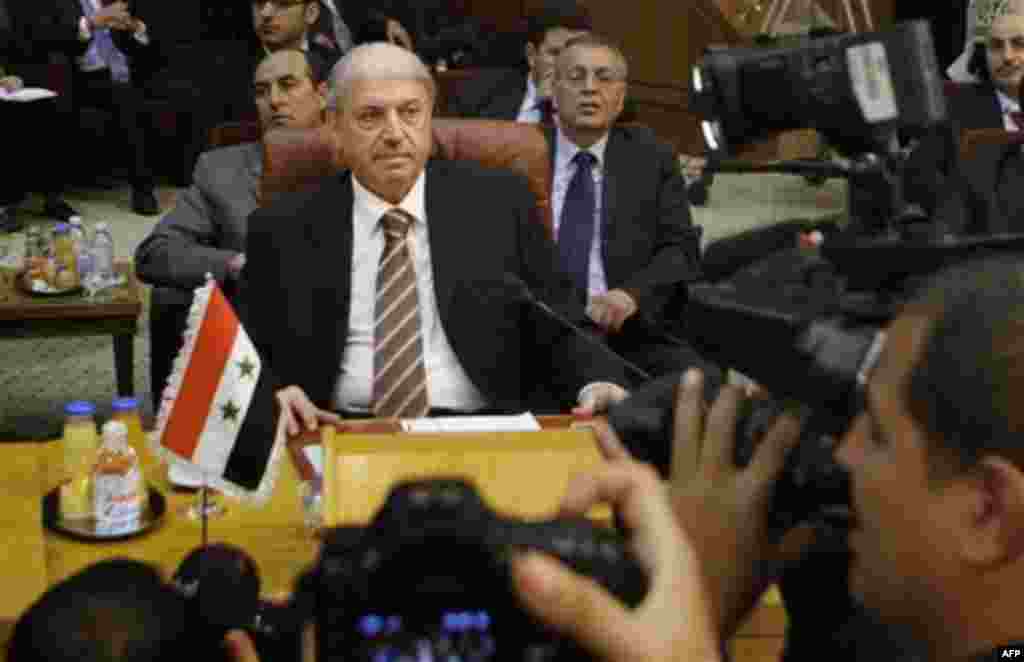Yussef al-Ahmad, Syria's ambassador to the Arab League, is surrounded by cameramen during the Arab League emergency session on Syria at the Arab League headquarters in Cairo, Egypt, Saturday, Nov.12, 2011 . The Arab League has voted to suspend Syria from 