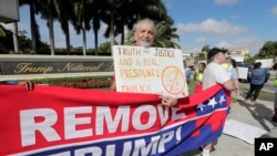 Ray Bonachea holds a sign in favor of the impeachment of President Donald Trump, outside of the Trump National Doral Miami golf resort, Dec. 17, 2019, in Doral, Fla. 