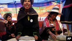 FILE - Aymara indigenous women grind grains of quinoa during a ceremony to celebrate the near completion of the International Year of Quinoa in Oruro, Bolivia, in 2013..