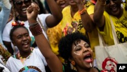 FILE - A woman raises her fist as she shouts slogans during a Black Women´s March against racism, violence and social inequality, on Copacabana beach in Rio de Janeiro, Brazil, July 31, 2022.