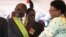 FILE: Zimbabwean President Robert Mugabe reacts with his deputy Joice Mujuru, during Defence Forces Day in Harare, Tuesday, Aug. 14, 2012.