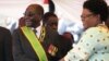 FLASHBACK: Zimbabwean President Robert Mugabe reacts with his deputy Joice Mujuru, during Defence Forces Day in Harare, Tuesday, Aug. 14, 2012.