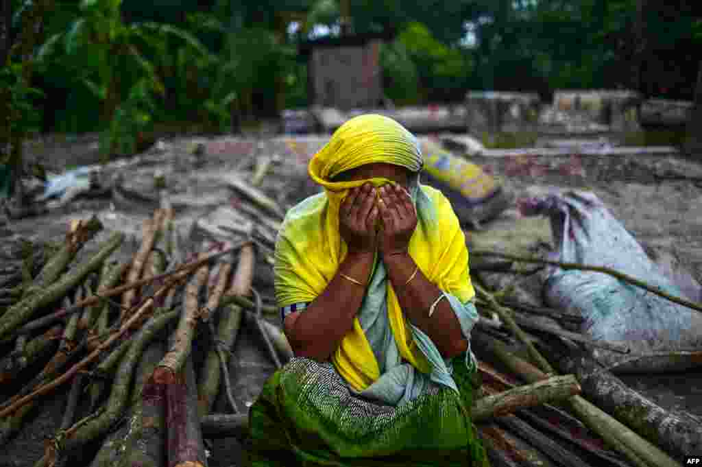 A Bangladeshi woman reacts as she sits next to her destroyed house washed away from the banks of the Padma River at Shariatpur some 40kms south of Dhaka on September 13, 2018, after aggressive erosion of land close to the river in Bangladesh. 