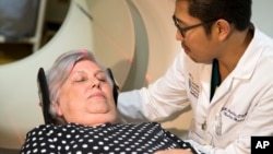 Judith Chase Gilbert is loaded into a PET scanner by a nuclear medicine technologist at Georgetown University Hospital in Washington D.C., May 19, 2015. Gilbert shows no signs of memory problems but volunteered for a new kind of scan as part of a study peeking into healthy brains to check for clues about Alzheimer's disease.