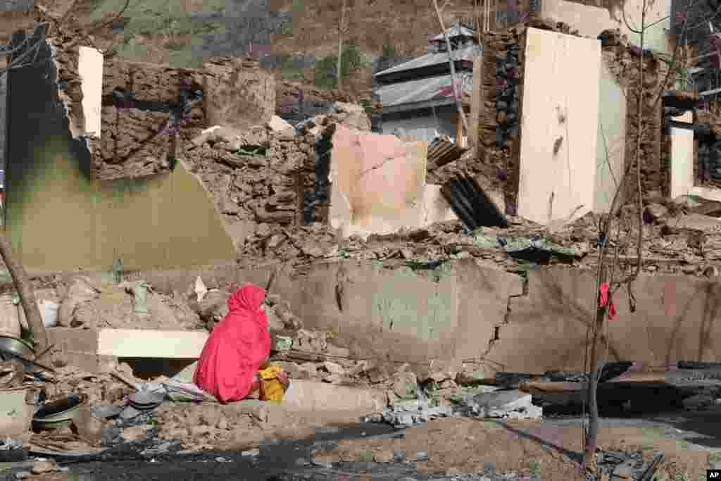 파키스탄령 카슈미르에서 여성이 인도군의 포격으로 부서진 집 사이에 앉아 있다.&nbsp;