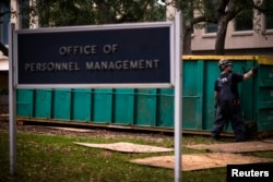 FILE - A worker is seen at the Office of Personnel Management in Washington, Oct. 17, 2013.