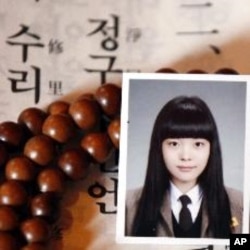 Photo of student on mother's prayer beads as she prays for daughter's success in college entrance examinations, Seoul, Nov. 8, 2011.