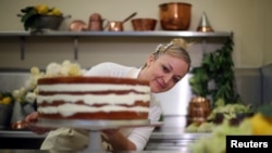 Claire Ptak, owner of Violet Bakery in Hackney, east London, puts finishing touches to a cake for the wedding of Prince Harry and Meghan Markle in the kitchens at Buckingham Palace in London, Britain, May 17, 2018. 