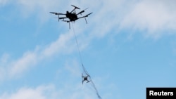 An Airspace Systems Interceptor autonomous aerial drone releases a kevlar net to capture a simulated hostile drone during a product demonstration in Castro Valley, California, March 6, 2017.
