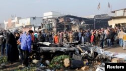 Orang-orang berkumpul di lokasi serangan bom di pasar di Baghdad timur, Irak, 8 Januari 2017. 