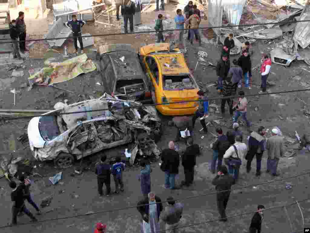 Civilians gather at the site of a car bomb attack at an outdoor market in Baghdad, Jan. 20, 2014. 