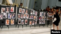 A woman places a photograph of one of the victims in the shooting at the Pulse gay nightclub, on a memorial during an Interfaith Service at First United Methodist Church in Orlando, Florida, June 14, 2016.