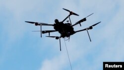 An Airspace Systems Interceptor autonomous aerial drone releases a kevlar net to capture a simulated hostile drone during a product demonstration in Castro Valley, California, March 6, 2017.