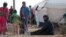 FILE - Iraqi refugees rest near tents in an Iraqi refugee camp in the village of Mabrouka, western countryside of Ras al-Ain, Syria, Jan. 31, 2016. 