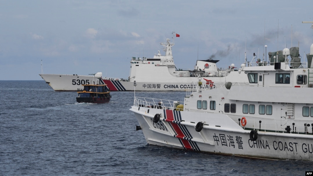 這張拍攝於2023年8月22日的照片顯示,中國海岸警衛隊船隻(左、右)在有爭議的南中國海圍堵了一艘由菲律賓海軍包租的菲律賓民用船向菲律賓海軍艦艇運送物資。