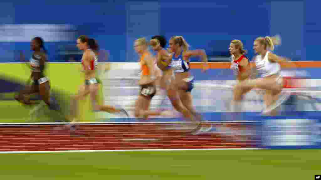 In this photo taken with slow shutter speed athletes compete in the 100m hurdles for the heptathlon at the European Athletics Championships in Amsterdam, the Netherlands.