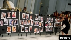 A woman places a photograph of one of the victims in the shooting at the Pulse gay nightclub, on a memorial during an Interfaith Service at First United Methodist Church in Orlando, Florida, June 14, 2016.