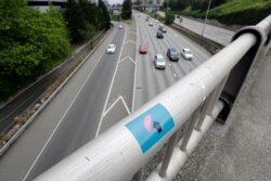 A protest sticker is posted on a handrail above Interstate 5 on July 4, 2020, in Seattle, where two protesters on the highway were injured after a car barreled into them earlier in the day. One of the victims died.