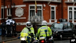 Police motorcyclists briefly stop outside the Ecuadorian embassy in London, Feb. 13, 2018.