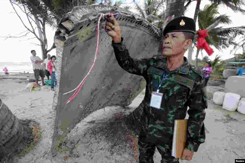 Thai army soldier inspects a piece of suspected plane wreckage which has been found off the coast of southern Thailand in Nakhon Si Thammarat province, Jan. 24, 2016. 