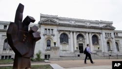 FILE - A man walks past the historic Carnegie Library building in Washington. Philanthropist Andrew Carnegie funded 3,000 public libraries in English-speaking countries. Like Carnegie, philanthropists today are pouring money into a global drive to make ci