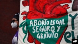 ARCHIVO - Una mujer sostiene una pancarta mientras manifestantes por el derecho al aborto se manifiestan frente al Congreso Nacional en el "Día por la Despenalización del Aborto en América Latina y el Caribe", en la Ciudad de México, el 28 de septiembre de 2020.