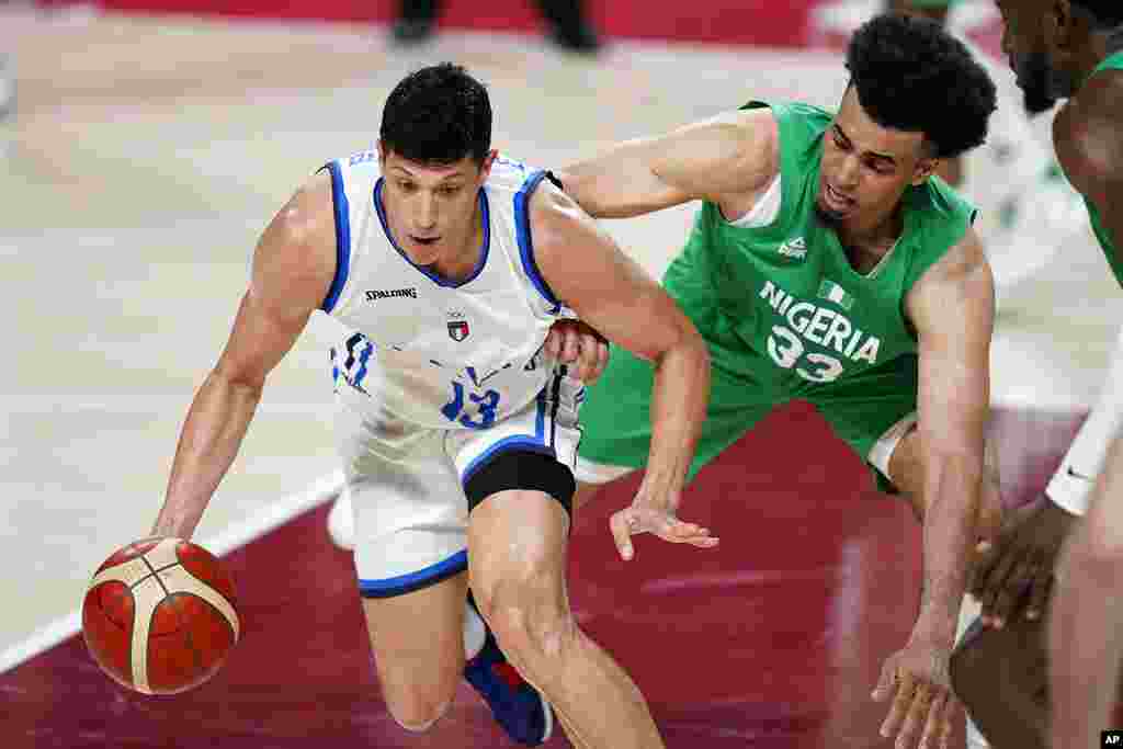 Italy&#39;s Simone Fontecchio (13), left, drives around Nigeria&#39;s Jordan Nwora (33), right, during men&#39;s basketball preliminary round game at the 2020 Summer Olympics, Saturday, July 31, 2021, in Saitama, Japan. (AP Photo/Charlie Neibergall)