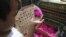 An Indonesian child holds a colored chick to be sold at a chicken farm in Jakarta, Indonesia, December 18, 2012.