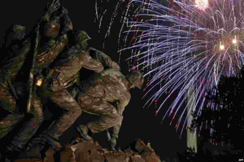 The United States Marine Corps War Memorial, better known as the Iwo Jima Memorial, is seen in Arlington, Va., Monday July 4, 2011, as fireworks burst over Wasington, during the annual Fourth of July display. (AP Photo/Carolyn Kaster)