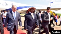 Thủ tướng Israel Benjamin Netanyahu (trái) đi cùng Tổng thống Uganda Yoweri Museveni (phải) sau khi đến để dự lễ kỷ niệm 40 năm Chiến dịch Entebbe tại sân bay Entebbe ở Uganda, ngày 4 tháng 7 năm 2016. 