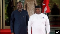 FILE - Omar Touray, left, president of the ECOWAS Commission, welcomes Sierra Leone's President Julius Maada Bio, right, for the ECOWAS meeting in Abuja, Nigeria. Thursday, August 10, 2023.