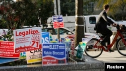 FILE - Various campaign signs crowd one corner of Washington, D.C., in November 2014. 