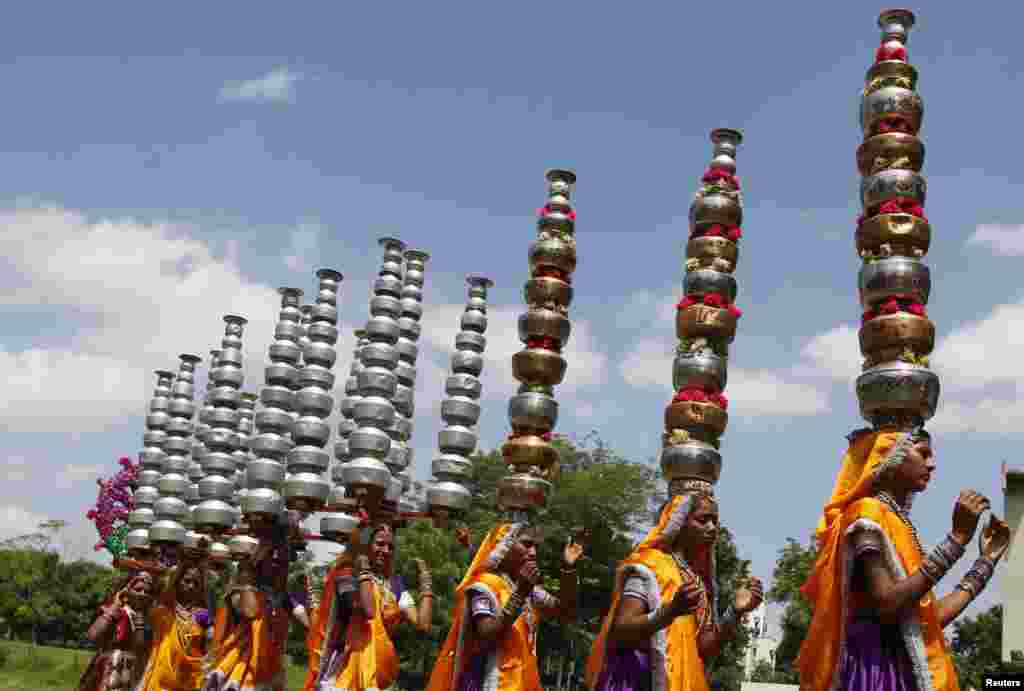 Women dressed in traditional clothing balance pitchers on their heads during practice for the "garba" dance ahead of Navratri festival in the western Indian city of Ahmedabad.