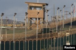 FILE - A military member observes from a watch tower at Camp Delta at the U.S. Detention Center in Guantanamo Bay, Cuba, in April 2010..